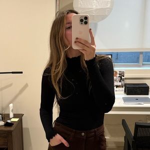 Black Free People bodysuit with ruffled sleeves and neck